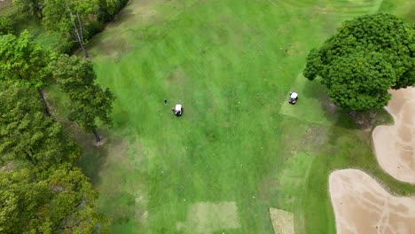 drone footage captures golfers on a lush, green course in phuket, thailand, highlighting the vibrant landscape and serene atmosphere