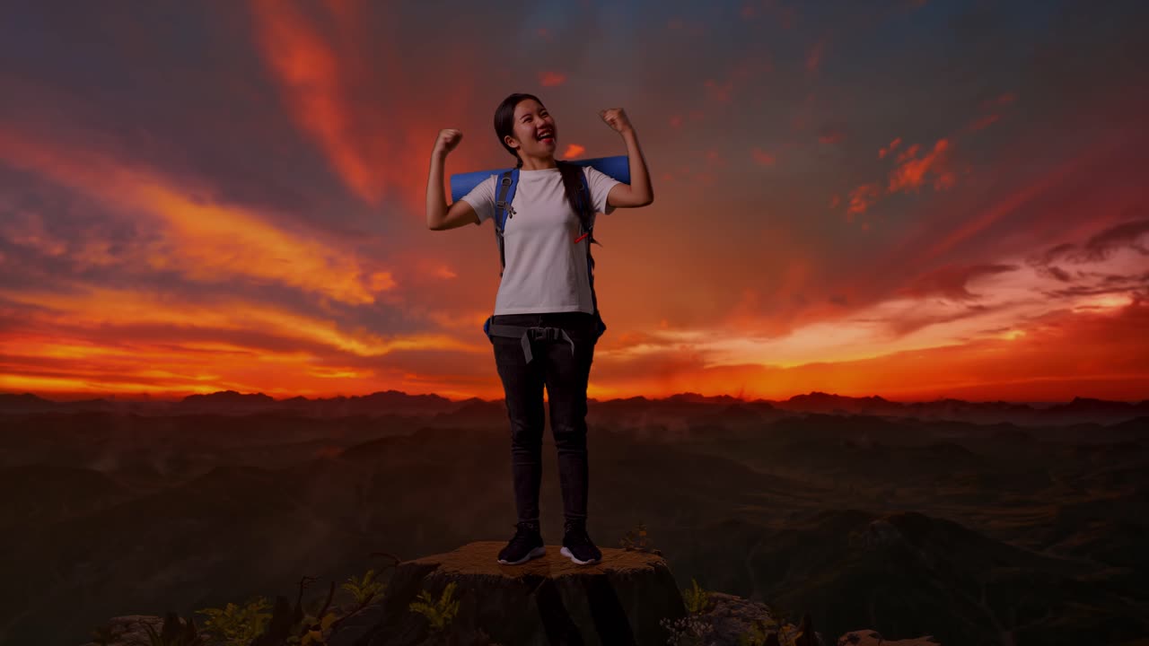 해가 지면 정상에 오르는 성공을 축하하는 여성