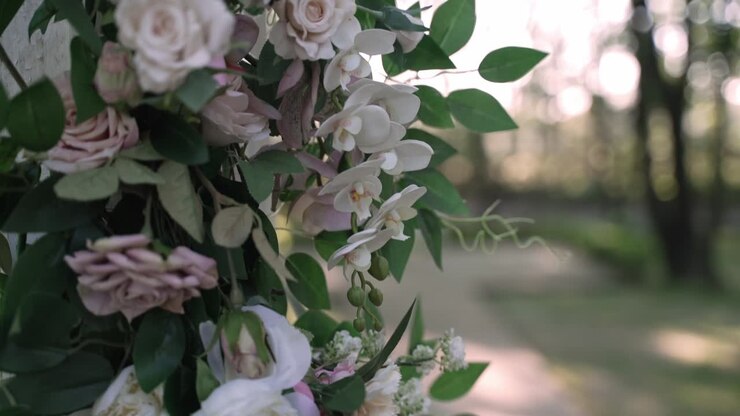Close-up of a flower arrangement with white and pink blooms in an outdoor garden setting
