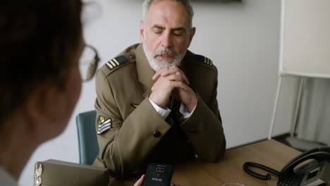 young woman talking with military man