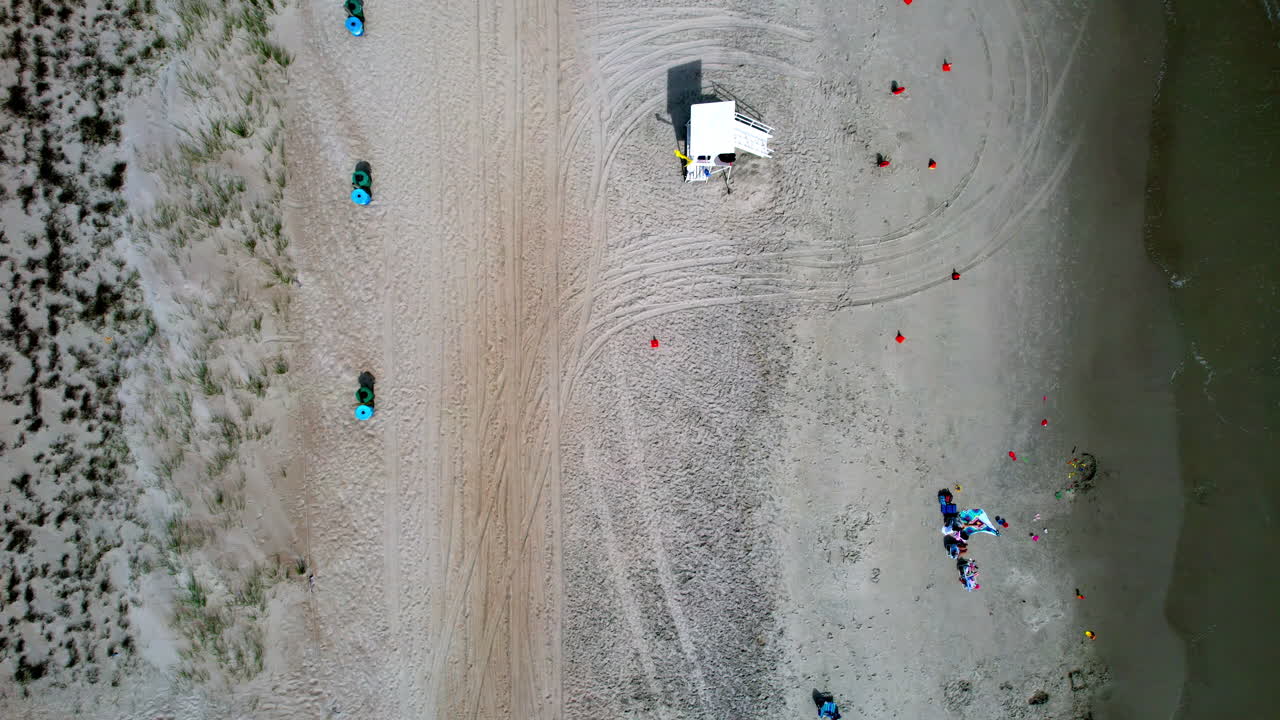 모래 위에 몇 명의 사람들과 함께 해안선의 하향 각도 드론  ⁇