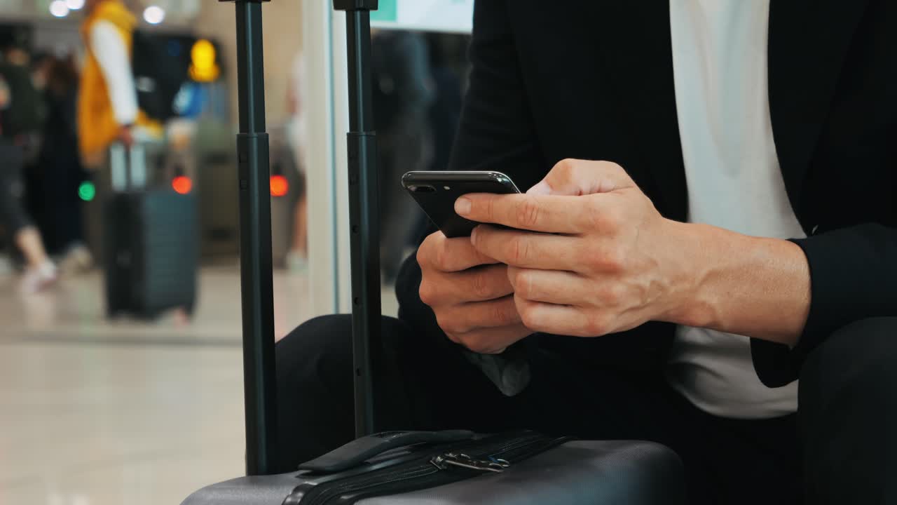 Businessman Uses Laptop, Waiting for a Flight in Airport Terminal or train station, Traveling Entrepreneur Working Online On Computer Sitting in a Boarding Lounge of Airline Hub with Airplanes