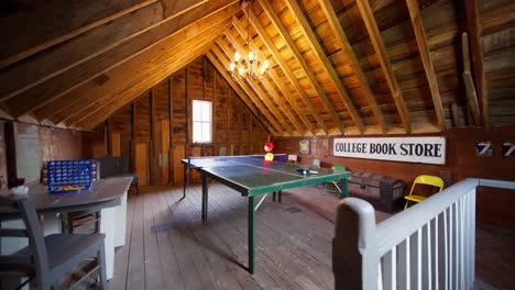 wide push in shot of a vintage gaming room on the upper level of a barn with a ping pong table