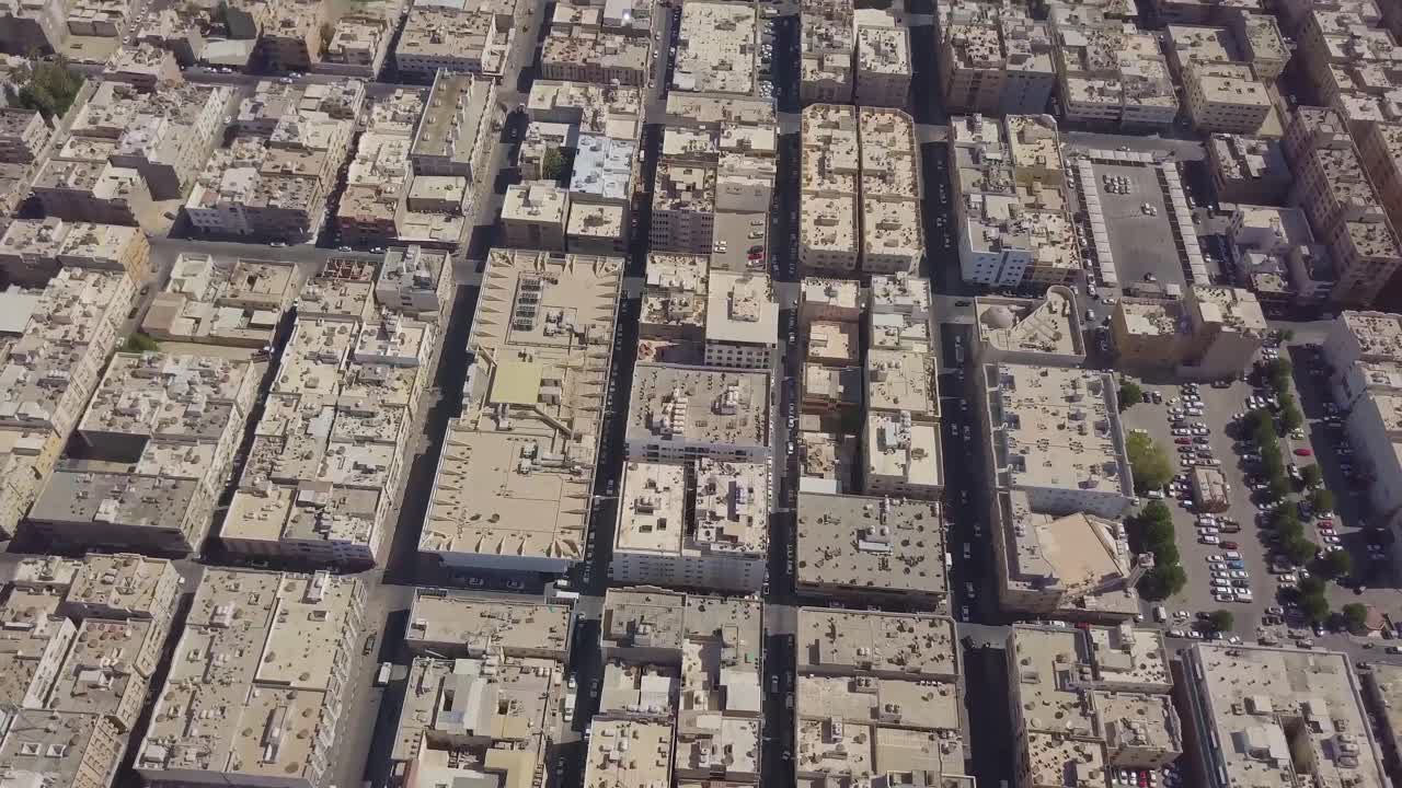 Veduta aerea di auto nel traffico nella città di Khobar Sweikit, con lo skyline di Khobar e la corniche visibili.