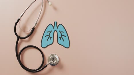 video of close up of stethoscope with lungs on pink background