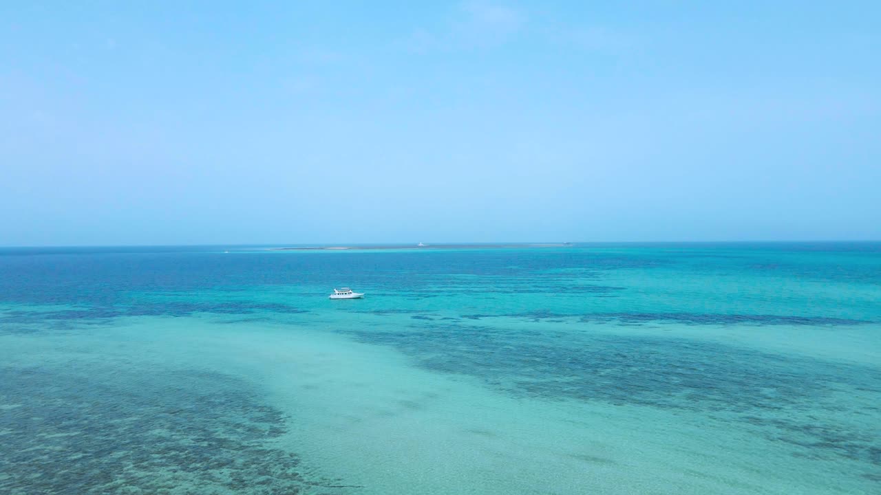 Serene coastal scene with clear turquoise waters meeting a bright blue sky, perfect for relaxation and travel imagery.