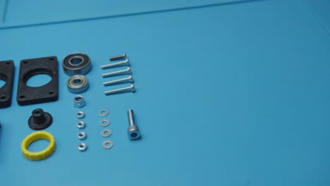 pan right small parts prepared for assembly blue background