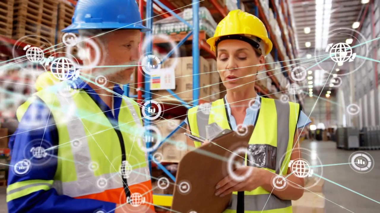Operaio che indica l'avvio di una sovrapposizione di dati, mentre un team di magazzino cammina verificando i pallet con un blocco note.