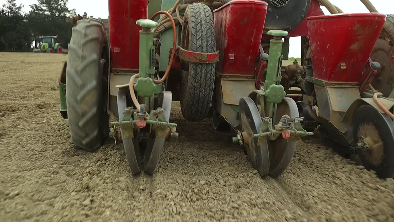 Close up of hydraulic seed drill machine in action in agricultural natural organic soil land