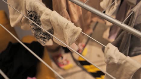 white socks hanging to dry indoors on a clothes rack, close-up - 4k.