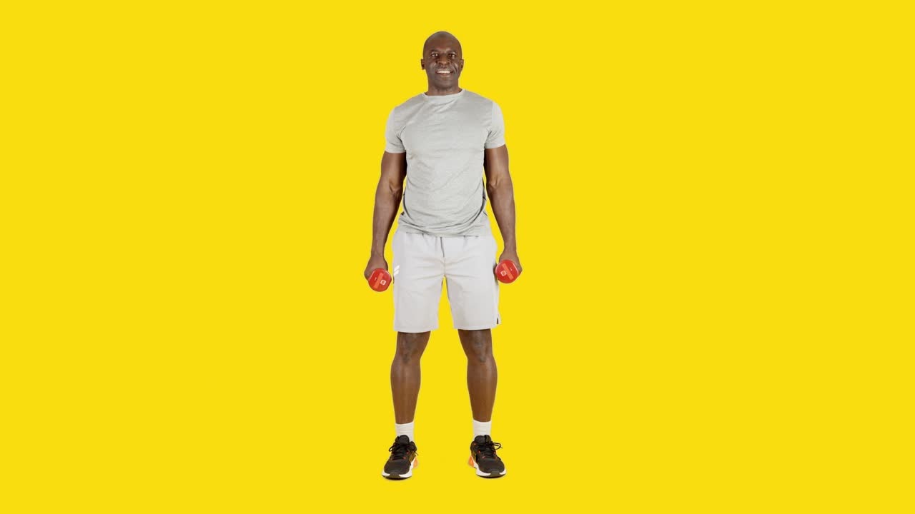 Homme africain faisant l'exercice de curl biceps avec des haltères en alternant les bras