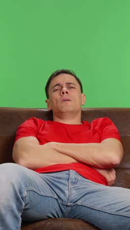 tired man falls asleep watching a movie on tv