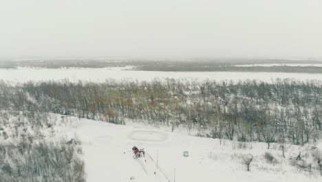 Pista-De-Esquí-En-Una-Colina-Nevada-En-Invierno,-Madera-Y-Vista-Superior-Del-Río