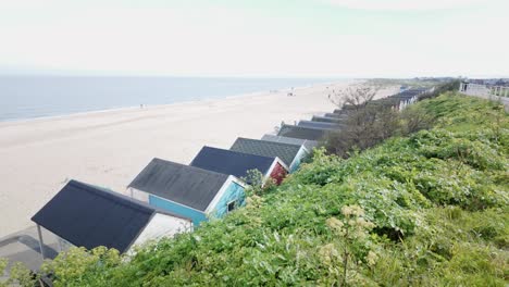 seaside view with family beach huts from coastal sand dune grasses southwold