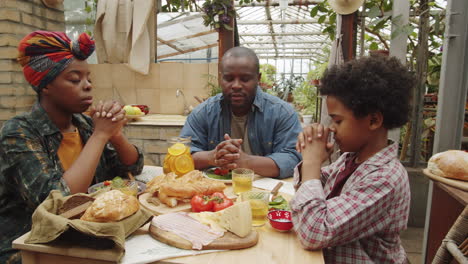 Afroamerikanische-Familie-Betet-Vor-Dem-Essen-Im-Gewächshaus