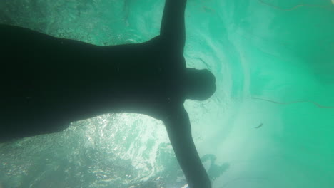 hombre nadando en la piscina bajo el hotel resort cocotero bajo el agua disparó a cámara lenta