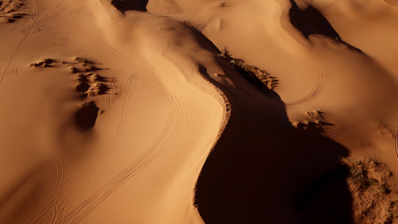 A drone hovers overhead, filming pink dunes streaked with rich hues and organic forms in southern Utah.