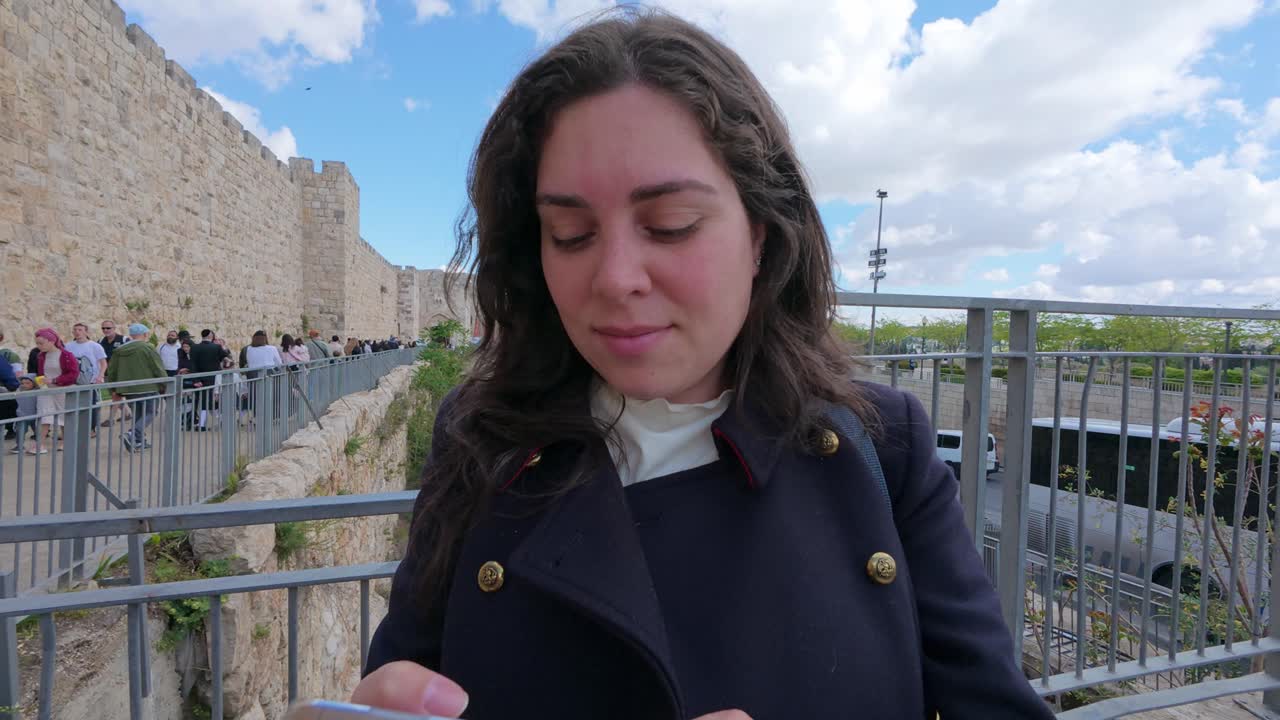 Woman using smartphone near the Old City Walls