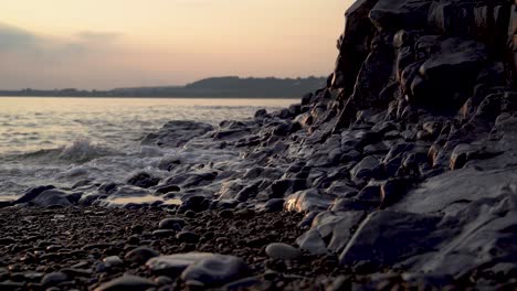 Wellen-Waschen-über-Kiesstrand-Und-Felsen-Am-Fuße-Der-Klippe,-Ogmore-On-Sea,-Südwales,-Großbritannien