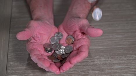 windfall-of-coins-drop-into-a-senior-retirees-hands-symbolizing-smaller-windfalls-of-money-in-old-age