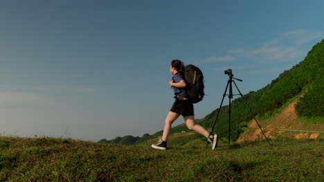 young-female-asiatic-model-backpacking-on-mountains-trip-taking-a-selfie-with-professional-camera-on-tripod-to-sharing-on-her-social-media-account-as-influencer