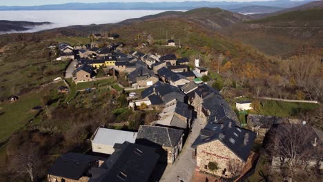 aerial view of a charming mountain village emerging from clouds