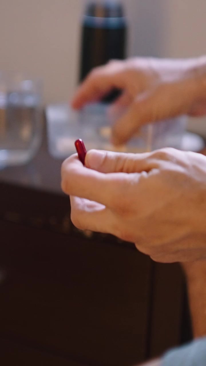 Persona che Assume Farmaci da un Contenitore di Plastica