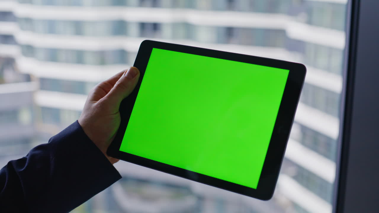 Businessman using tablet with green screen in office