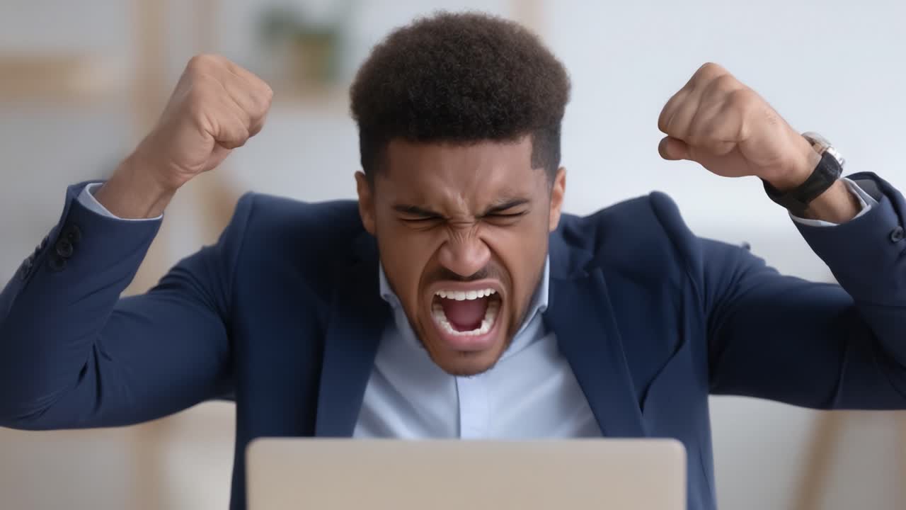 Frustration and Anger: A Young Businessman Expresses His Emotions while Working at His Laptop in a Modern Office Environment
