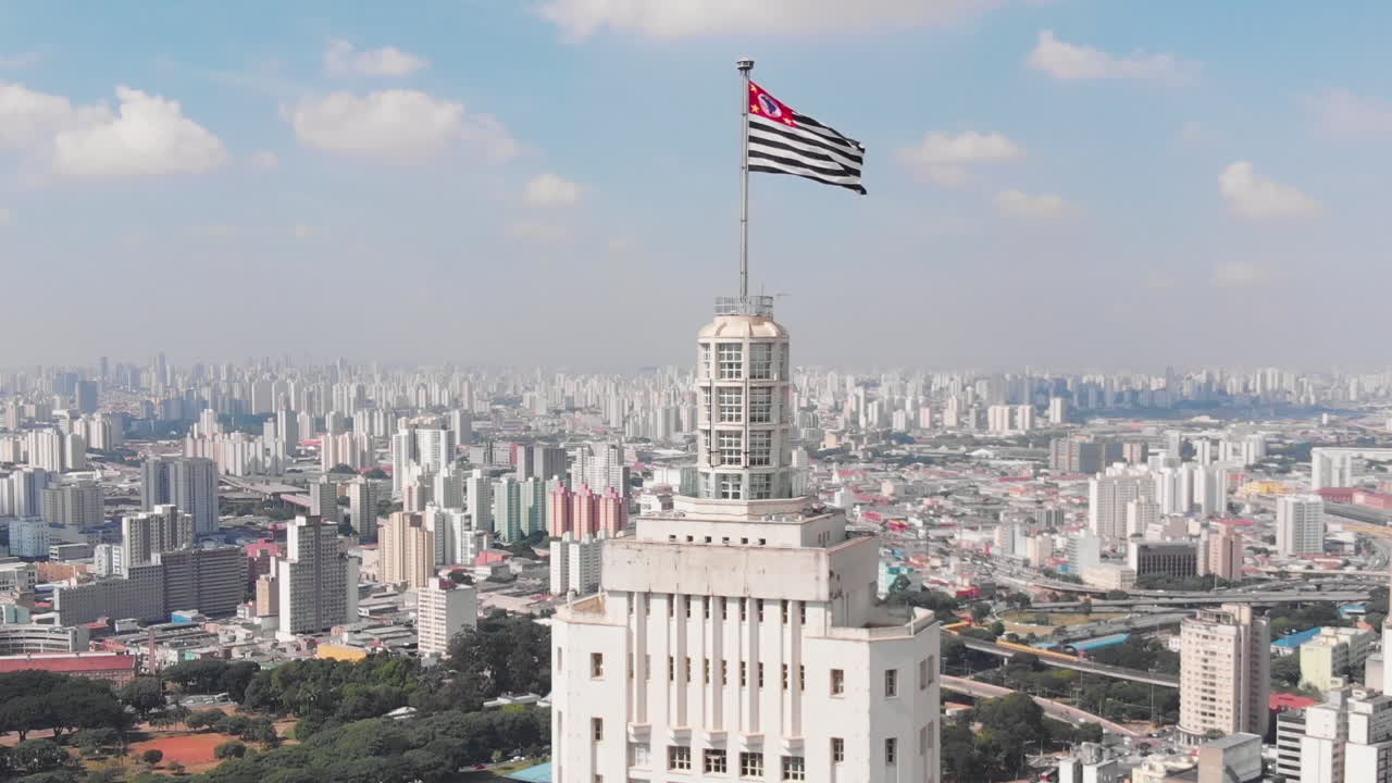 Aerial view of Altino Arantes building, called Banespao with the flag fluttering, at sunset, Sao Paulo downtown, Brazil