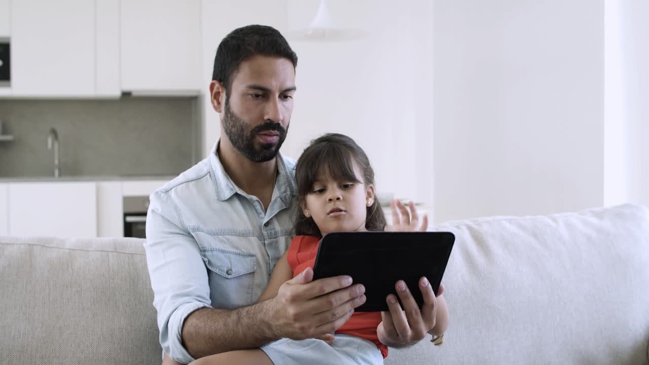 papá y su linda hija usando una aplicación en línea en la tableta