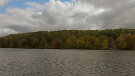 push towards trees and over lake in autumn in the hudson valley in new york on a beautiful day