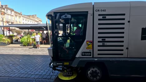 street cleaner passes by a bustling cafe