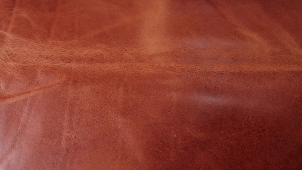 una hermosa pieza de cuero de color caramelo rico con textura y pátina lista para ser utilizada para crear artículos de cuero en un pequeño taller artesanal