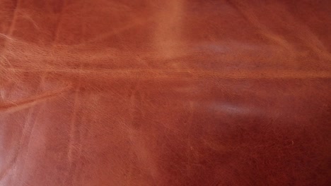 a beautiful rich caramel coloured piece of leather with texture and patina ready to be used to create leather goods in a small artisan workshop