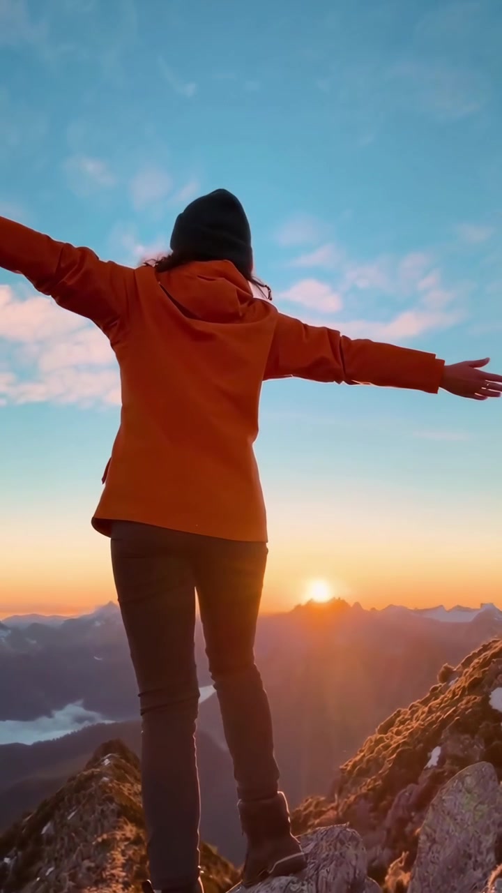 Un escursionista in piedi sulla vetta della montagna al tramonto