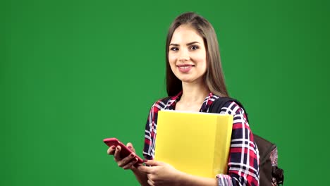 joven estudiante atractiva usando su teléfono inteligente sonriendo a la cámara