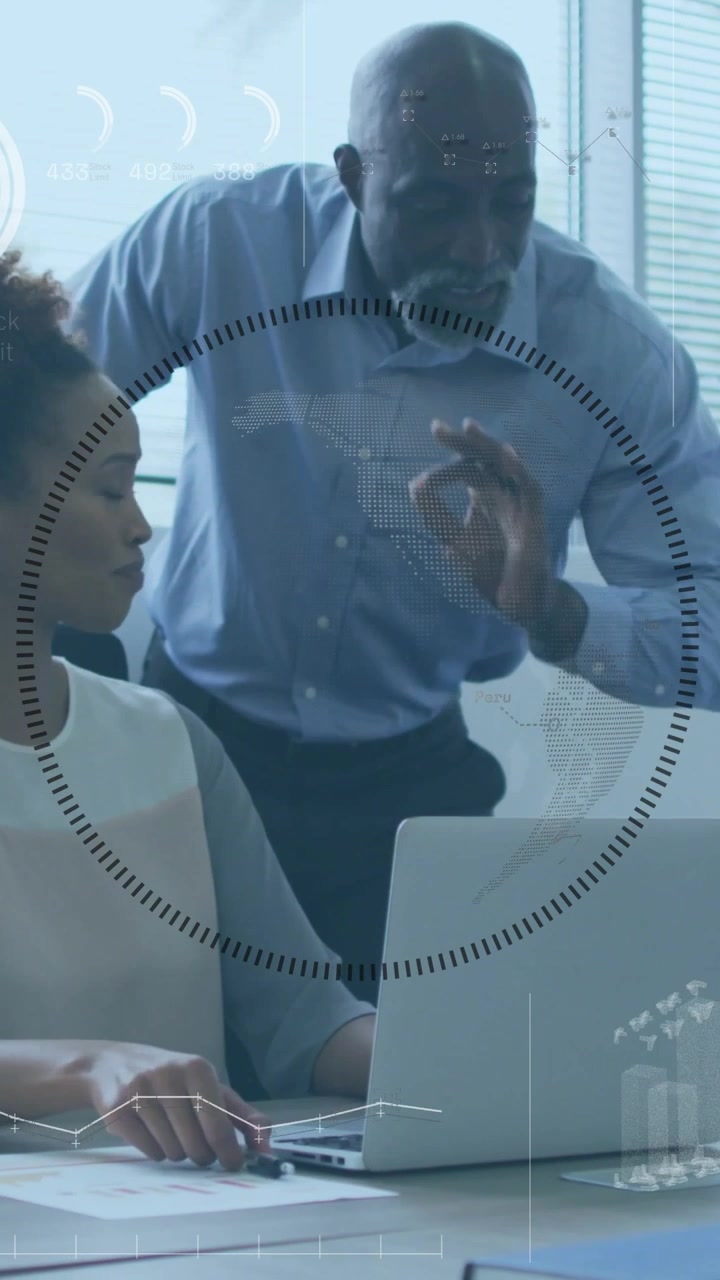 Vertical video: Manager leaning over office laptop pointing guiding while HUD showing charts