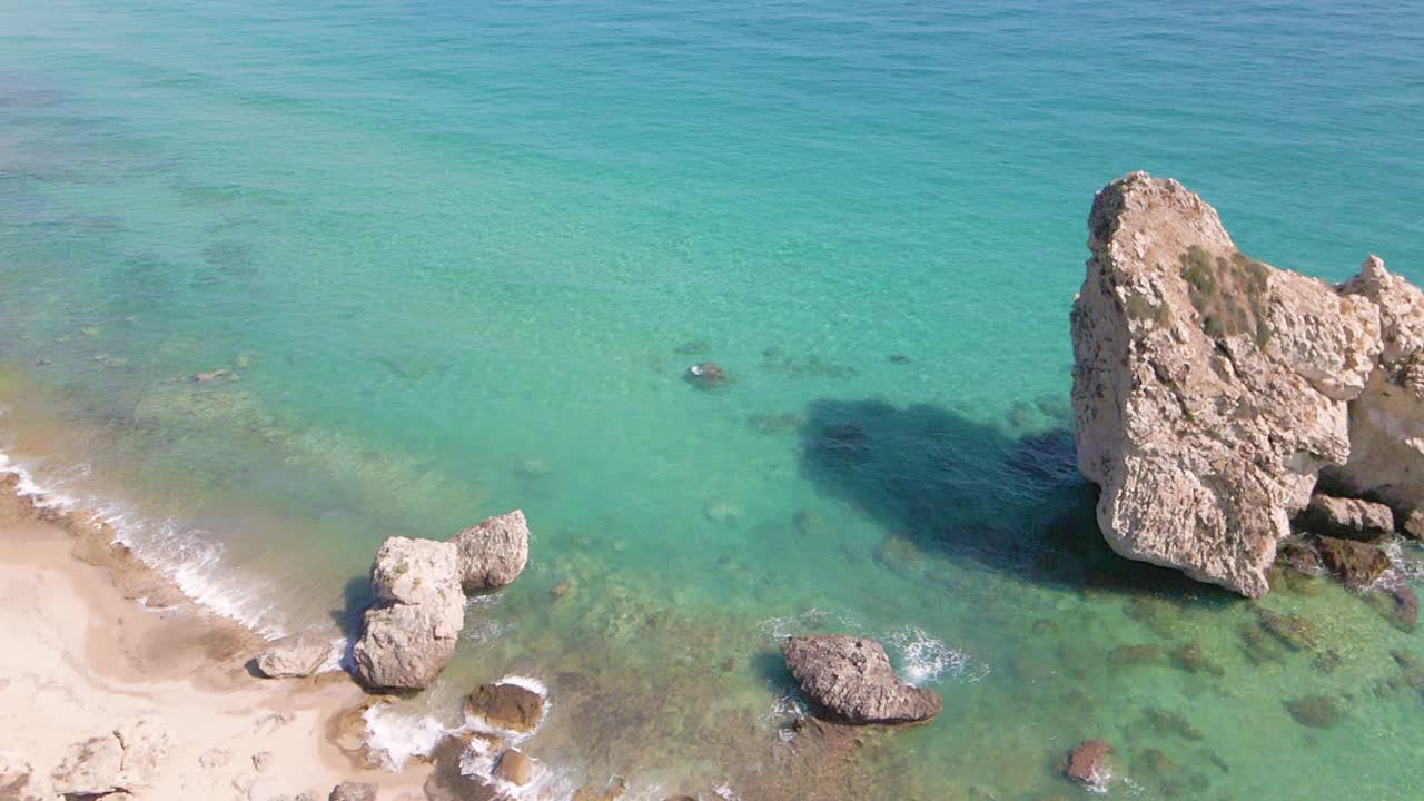 clip de drones sobre una hermosa playa con olas aplastando la costa en kavala, macedonia, grecia
