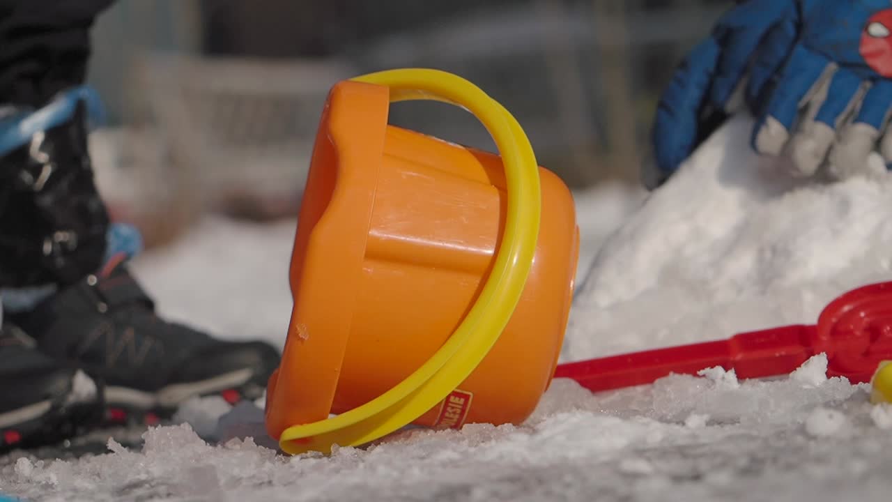 Lekar i snön med hink och spade
