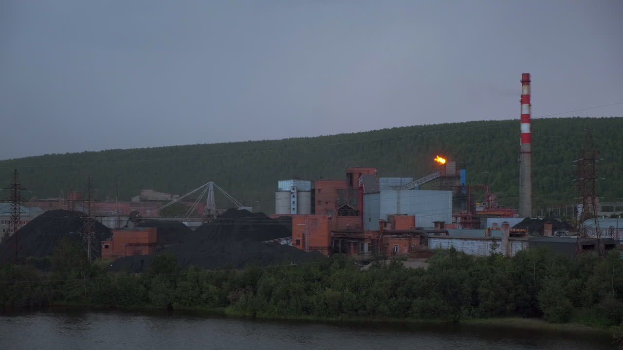 угольный завод в сумерках у реки