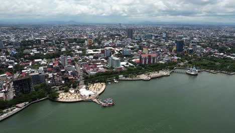 Luftaufnahme-Großer-Gebäude-In-Der-Stadt-Makassar,-Sulawesi,-Indonesien,-An-Einem-Sonnigen-Tag-Am-Wasser-Entlang