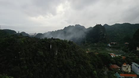 aerial flyover of the green and lush natural village in nin bihn, vietnam in high altitudes and cloudy forest
