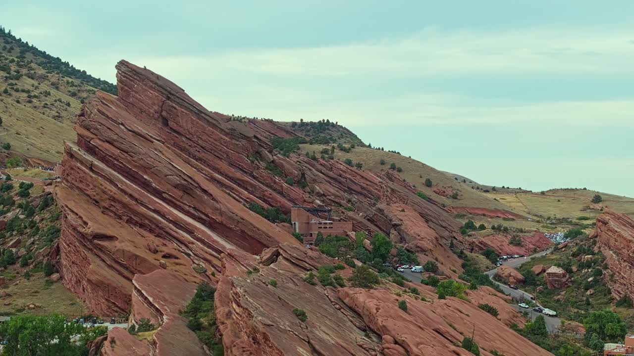 Drone ascends over amphitheatre between towering red rock formations in Colorado, iconic natural landscape