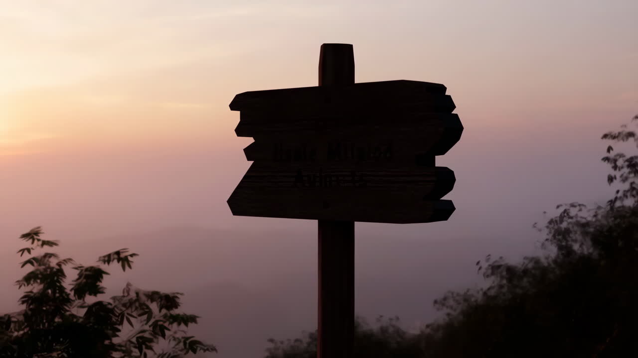 Silhouette of a Wooden Signpost Against a Colorful Sunset Sky