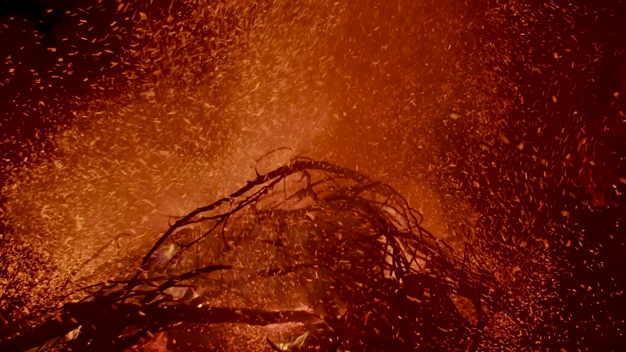 불타는 뜨거운 재와 불씨가 밤하늘의 큰 불에서 솟아오른다