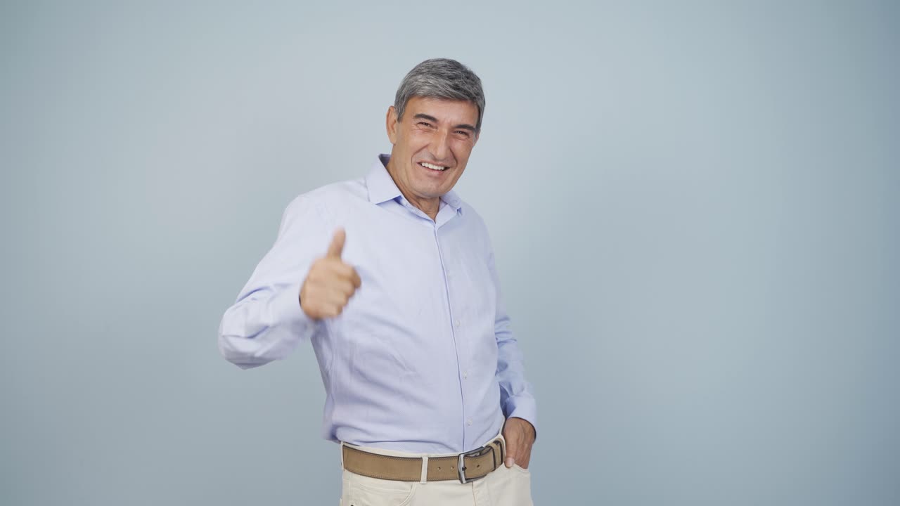 un anciano haciendo un gesto positivo a la cámara.