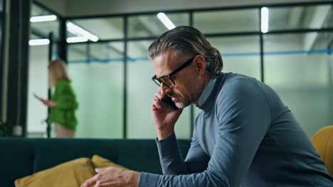 Serious-businessman-talking-mobile-phone-in-office.-Director-calling-telephone