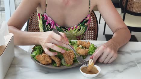 woman eating fried chicken salad