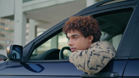 driver leaning car window looking on road at urban journey closeup.